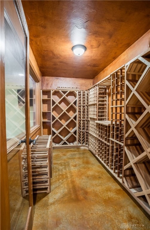 wine area featuring concrete flooring and wooden ceiling