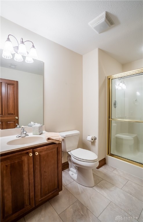 bathroom featuring vanity, tile patterned floors, toilet, and walk in shower