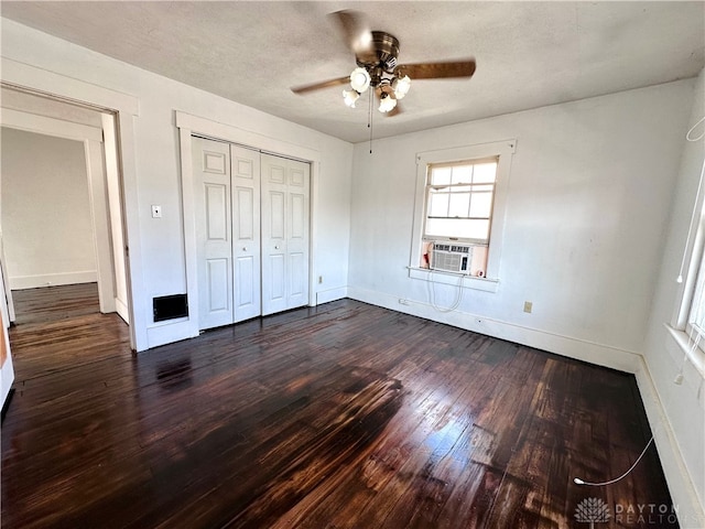 unfurnished bedroom with ceiling fan, a closet, cooling unit, and dark wood-type flooring