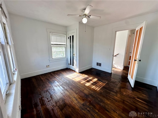 unfurnished bedroom with ceiling fan and dark wood-type flooring