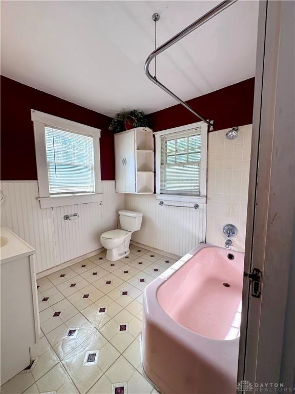 full bathroom featuring bathing tub / shower combination, a wealth of natural light, vanity, and toilet