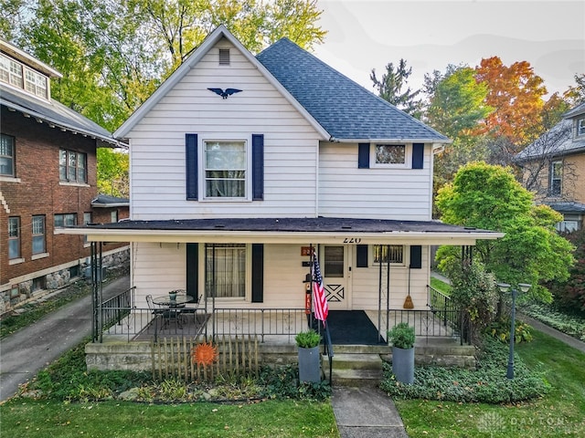 view of front facade featuring covered porch and a front yard