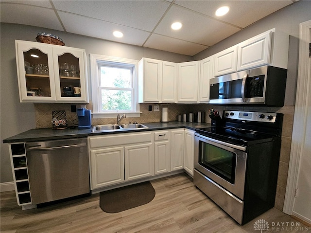 kitchen featuring white cabinetry, backsplash, appliances with stainless steel finishes, and light hardwood / wood-style flooring