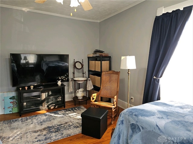 bedroom with crown molding, hardwood / wood-style flooring, and ceiling fan