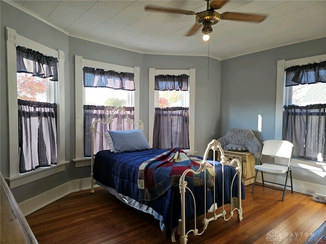 bedroom with ornamental molding, ceiling fan, and dark hardwood / wood-style flooring