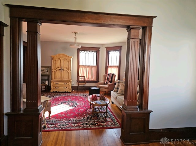 sitting room with ornate columns and hardwood / wood-style flooring