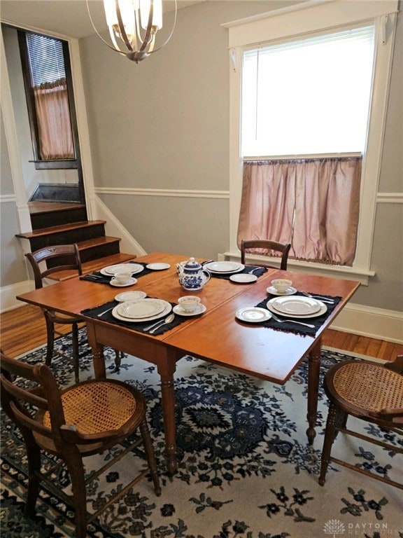 dining space with hardwood / wood-style flooring and a chandelier