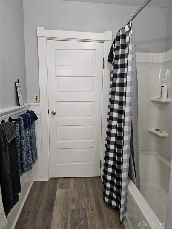 bathroom featuring wood-type flooring and shower / bath combo