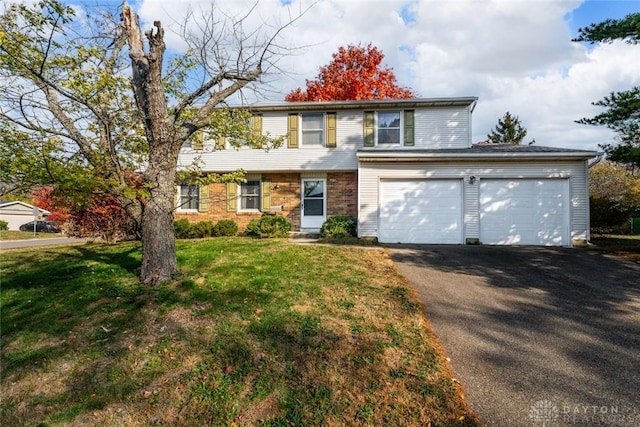 view of front of house featuring brick siding, aphalt driveway, an attached garage, and a front yard