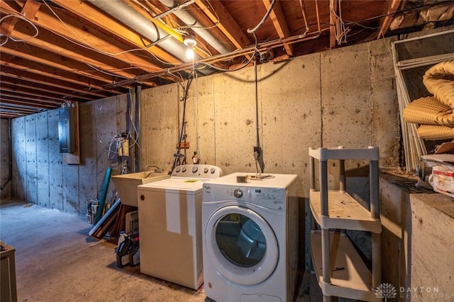 clothes washing area featuring a sink, washing machine and dryer, and laundry area