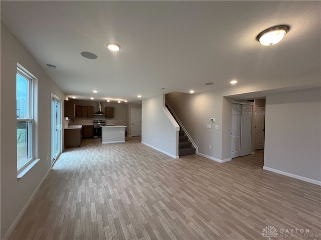 unfurnished living room featuring light hardwood / wood-style flooring and sink