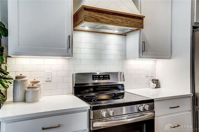 kitchen with custom exhaust hood, backsplash, and stainless steel range