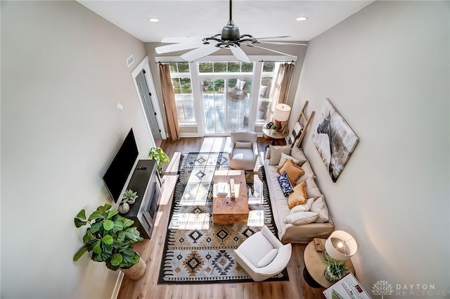 living room featuring hardwood / wood-style floors and ceiling fan