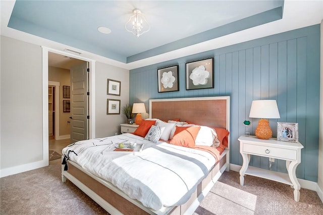 bedroom with carpet flooring and a raised ceiling