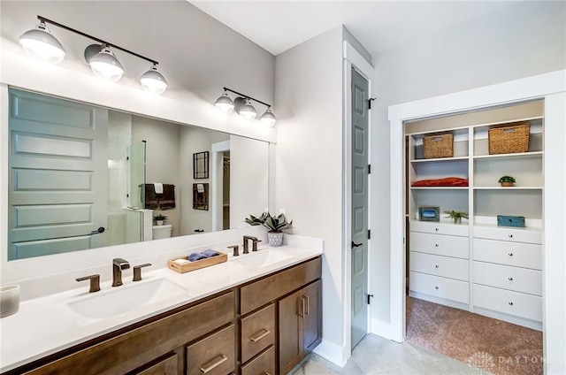 bathroom with a shower with door, vanity, and toilet