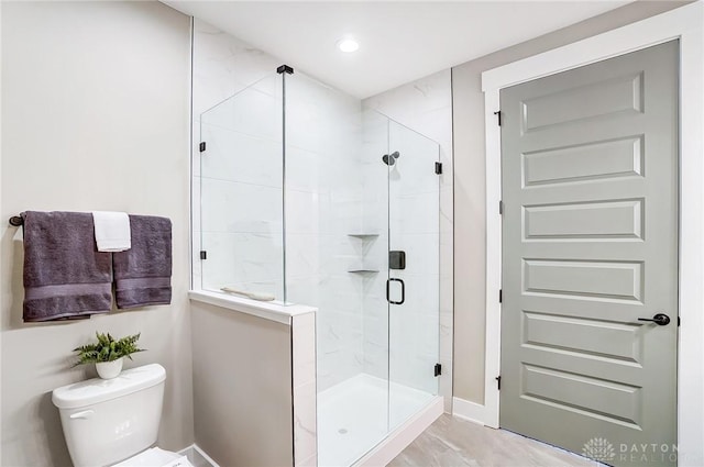 bathroom with an enclosed shower and toilet