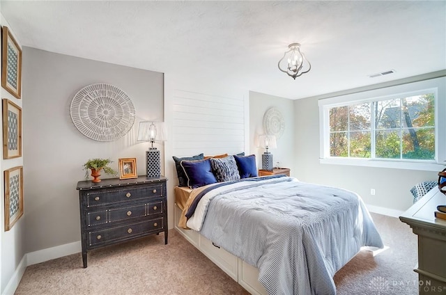 carpeted bedroom with a notable chandelier