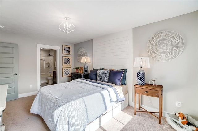 carpeted bedroom with connected bathroom and an inviting chandelier