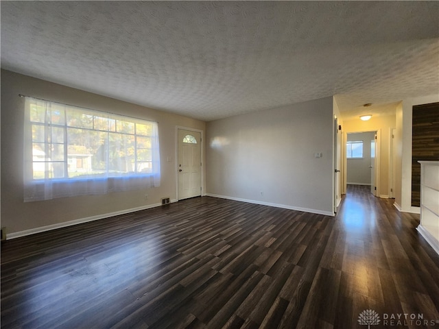 unfurnished living room with dark hardwood / wood-style floors and a textured ceiling