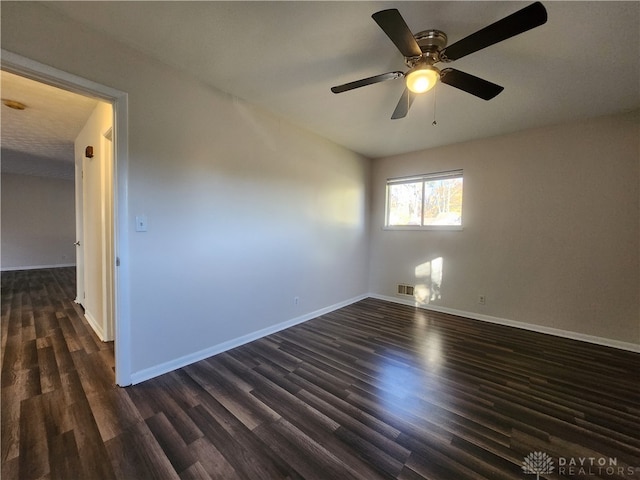 empty room featuring dark wood-type flooring and ceiling fan