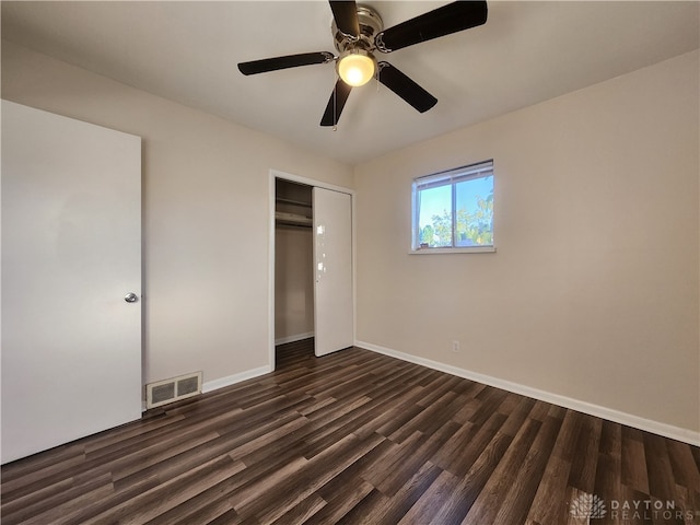 unfurnished bedroom with a closet, dark hardwood / wood-style floors, and ceiling fan