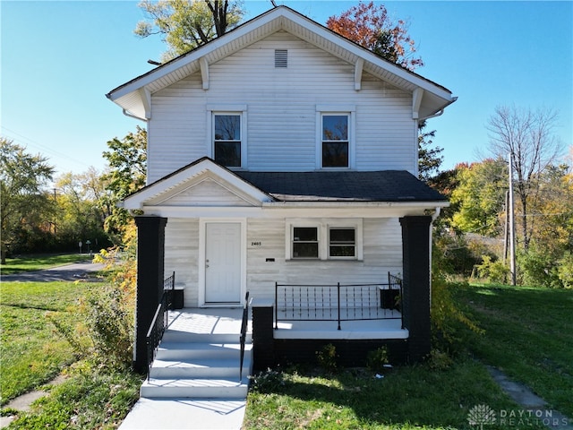 view of property with covered porch and a front lawn