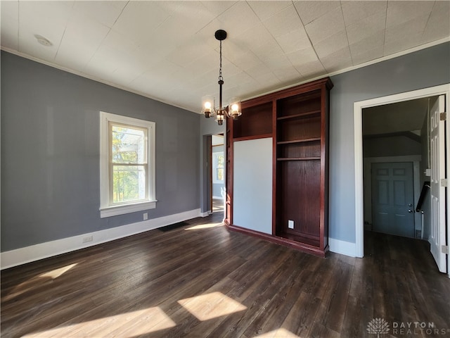 unfurnished dining area with crown molding, dark hardwood / wood-style floors, and a chandelier