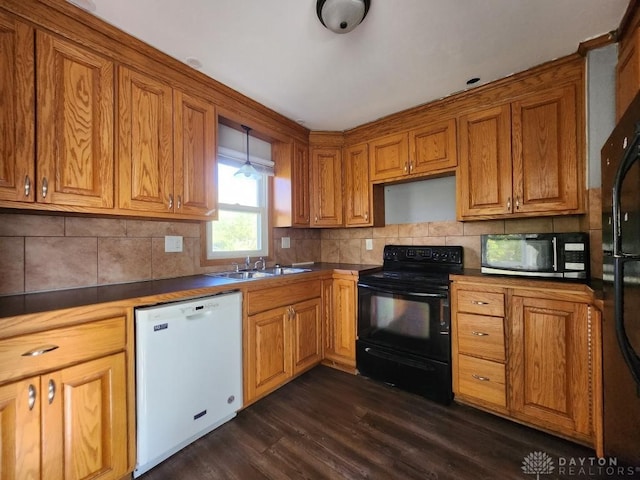 kitchen with dark hardwood / wood-style floors, tasteful backsplash, black appliances, and sink