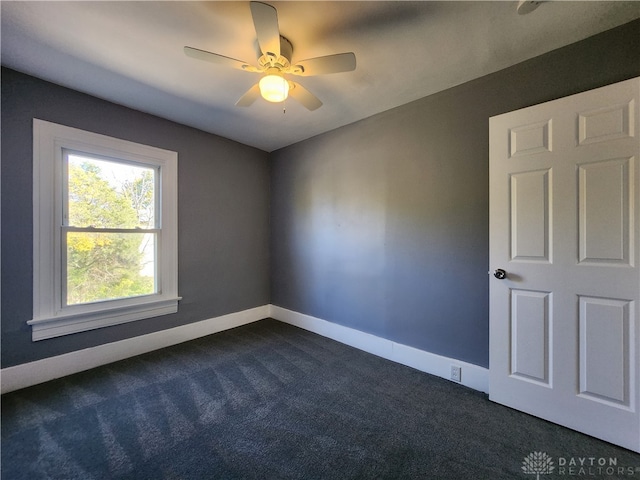 carpeted spare room with ceiling fan