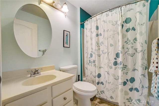 bathroom with a textured ceiling, tile patterned floors, vanity, toilet, and walk in shower