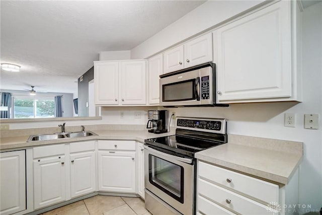 kitchen featuring white cabinetry, stainless steel appliances, sink, ceiling fan, and light tile patterned floors