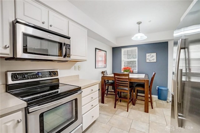 kitchen with decorative light fixtures, white cabinetry, stainless steel appliances, and light tile patterned flooring