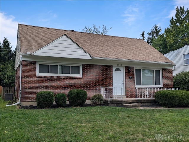 view of front of home featuring a front yard and central AC