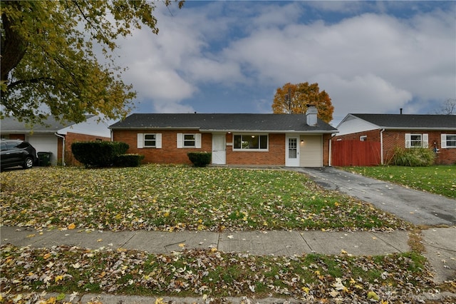 ranch-style house featuring a front yard and a garage