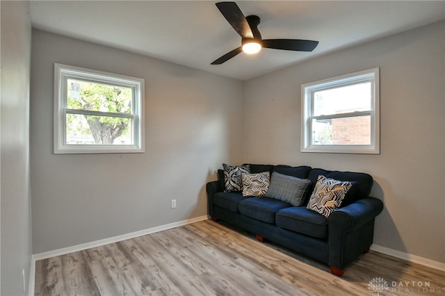 living room with light hardwood / wood-style flooring, a healthy amount of sunlight, and ceiling fan