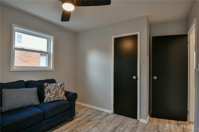 living room featuring light wood-type flooring and ceiling fan