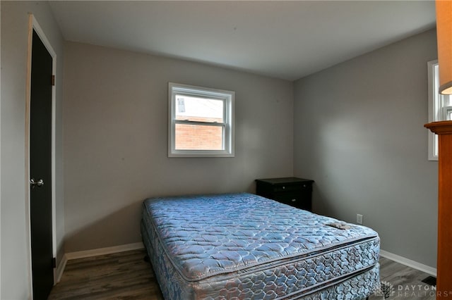 bedroom with dark hardwood / wood-style flooring