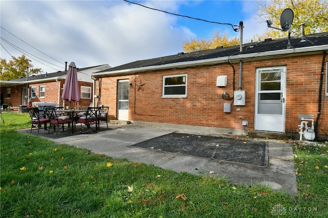 back of house featuring a patio area and a lawn