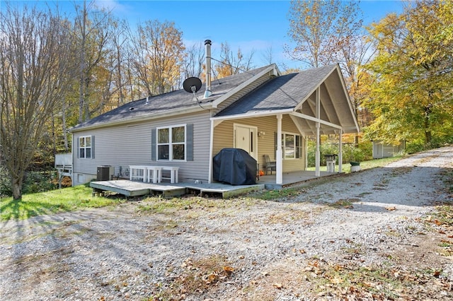 back of house featuring a storage shed and central AC unit