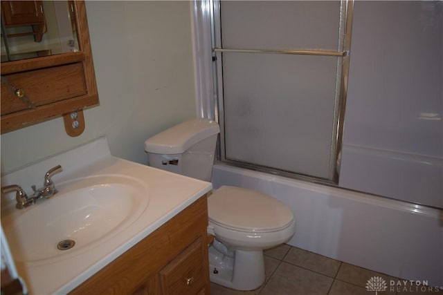 full bathroom featuring tile patterned floors, vanity, bath / shower combo with glass door, and toilet