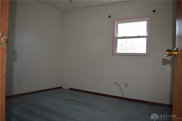 spare room featuring dark colored carpet