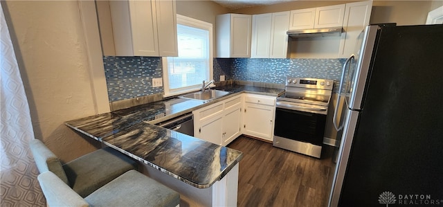 kitchen featuring decorative backsplash, kitchen peninsula, stainless steel appliances, sink, and white cabinetry