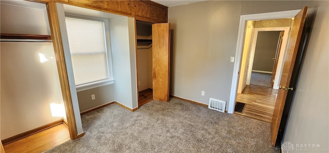 unfurnished bedroom featuring a closet, light carpet, and multiple windows