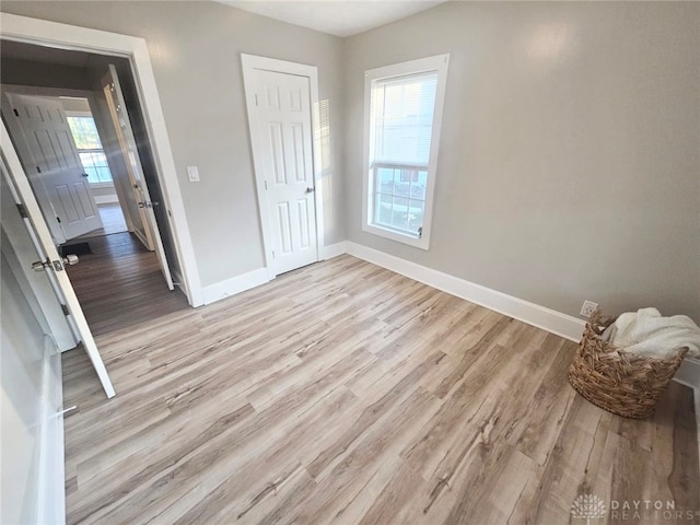 unfurnished bedroom with a closet and light wood-type flooring