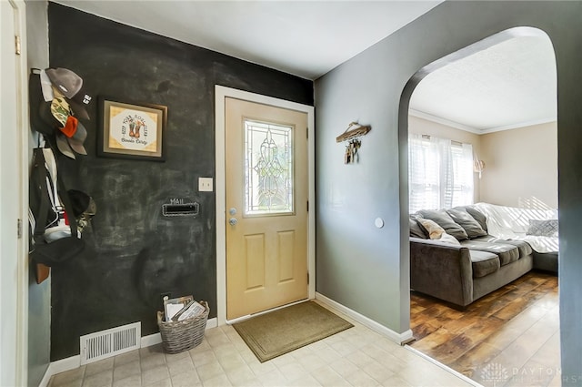 entryway featuring light wood-type flooring and ornamental molding