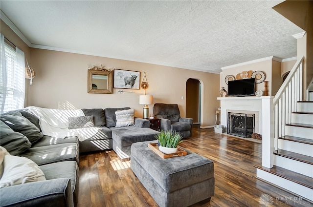 living room with dark hardwood / wood-style flooring, ornamental molding, and a textured ceiling