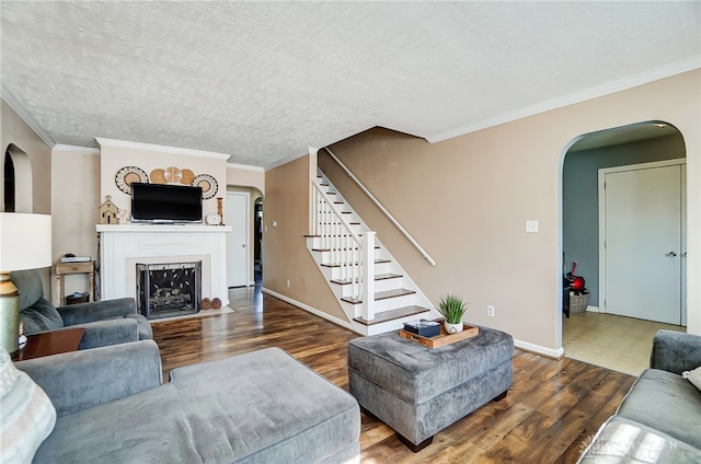 living room with a textured ceiling, dark hardwood / wood-style flooring, and crown molding