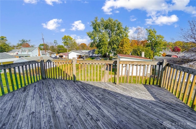 wooden terrace with a yard and a storage unit