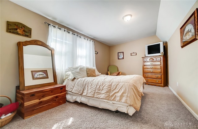 bedroom with lofted ceiling and light carpet