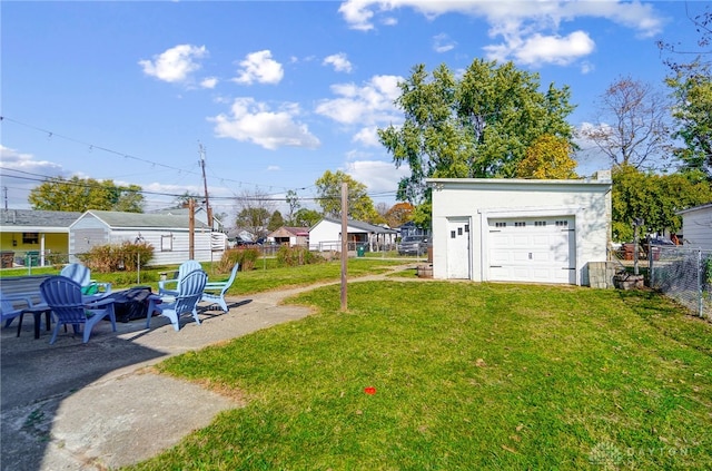 view of yard featuring a garage and an outdoor fire pit